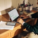 Build the Website First, Think About Goals Later — The Formula That Burns Your Money 2 Person working on laptop at wooden desk - website planning concept