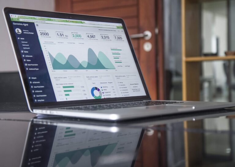 Laptop with analytics dashboard and code editor representing a modern WordPress agency tech stack